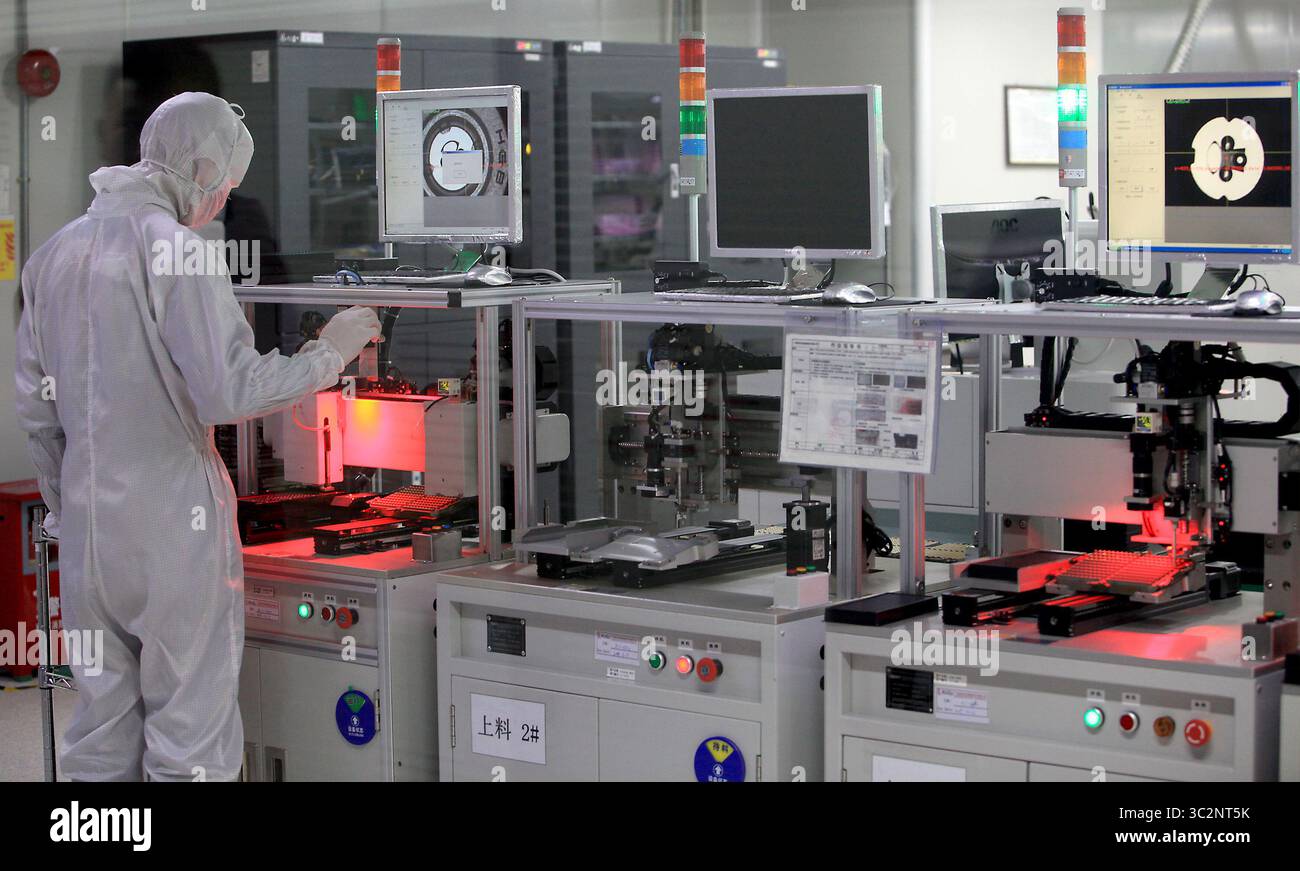 8 mai 2019 - Dongguan, PROVINCE DU GUANGDONG, CHINE - les techniciens chinois travaillent dans une salle blanche de Ruigu Optical Network Communications, l'un des secteurs commerciaux sous surveillance américaine, à Dongguan, province du Guangdong, le 8 mai 2019. Le président américain Donald Trump a donné suite à sa menace de relever les tarifs douaniers sur les exportations chinoises, marquant une forte escalade des tensions entre les deux plus grandes économies du monde. (Crédit image : © Todd Lee/ZUMA Wire) Banque D'Images