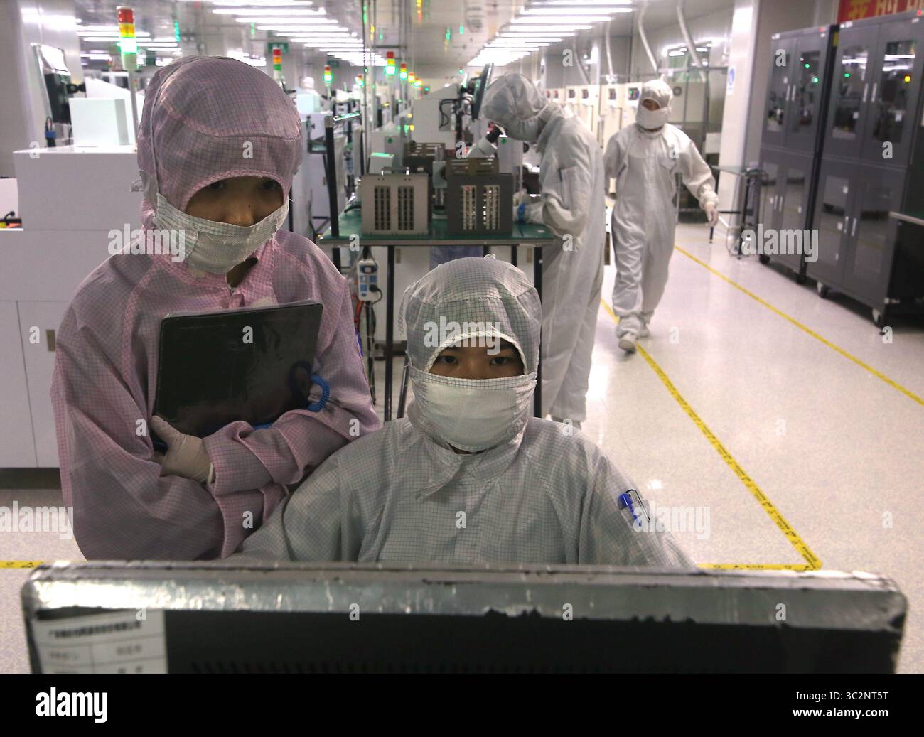 8 mai 2019 - Dongguan, PROVINCE DU GUANGDONG, CHINE - les techniciens chinois travaillent dans une salle blanche de Ruigu Optical Network Communications, l'un des secteurs commerciaux sous surveillance américaine, à Dongguan, province du Guangdong, le 8 mai 2019. Le président américain Donald Trump a donné suite à sa menace de relever les tarifs douaniers sur les exportations chinoises, marquant une forte escalade des tensions entre les deux plus grandes économies du monde. (Crédit image : © Todd Lee/ZUMA Wire) Banque D'Images