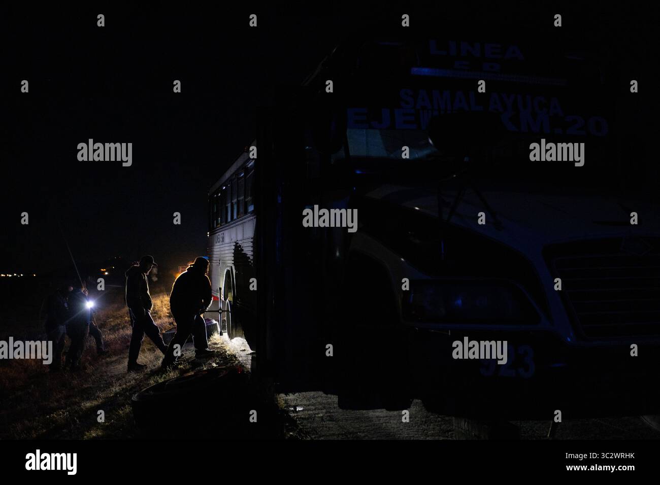 Les migrants descendent du bus Samalayuca la nuit près de Ciudad Juarez. Banque D'Images