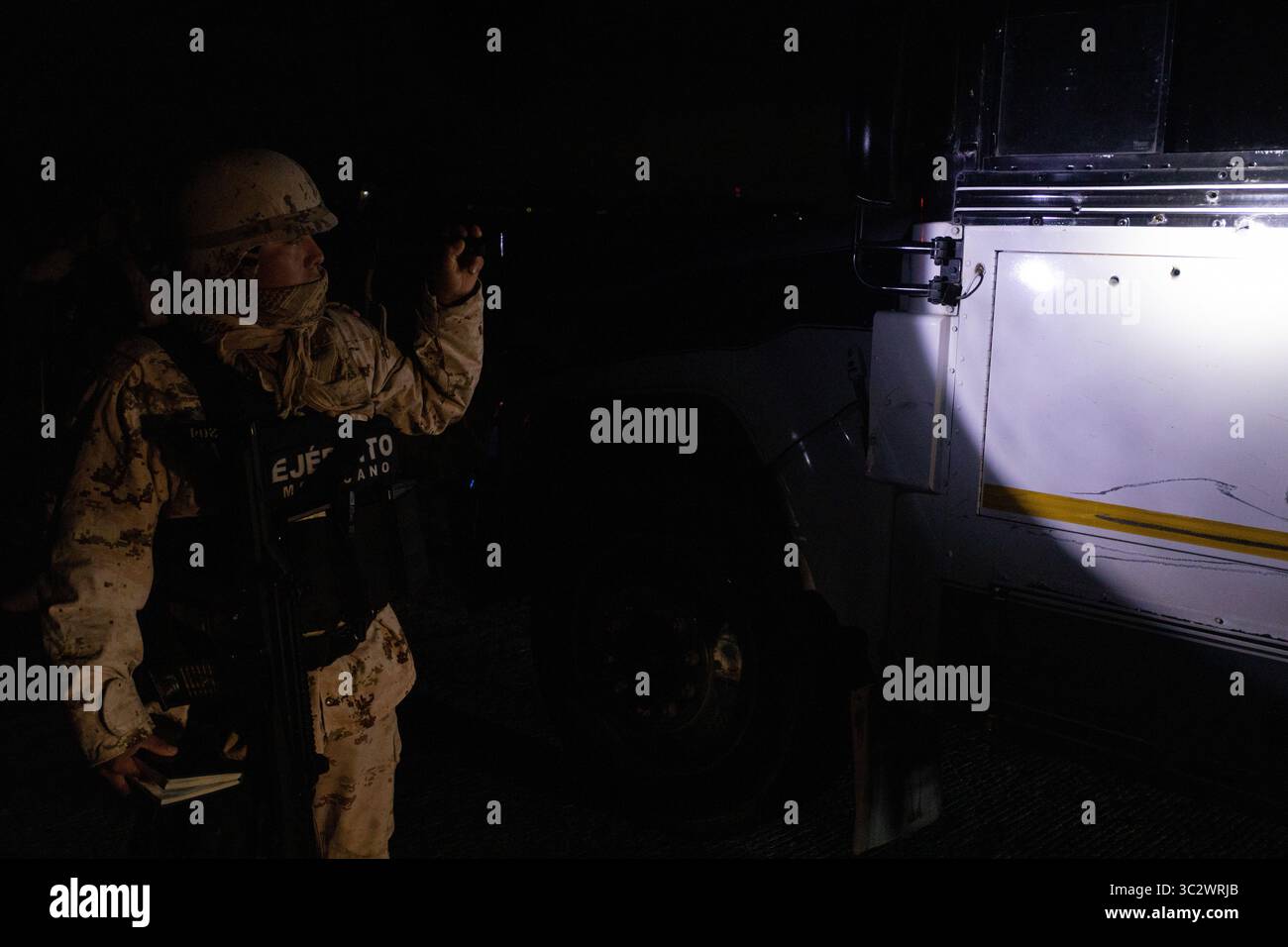 Un soldat inspecte un véhicule près de Ciudad Juarez pendant une opération de sécurité frontalière de nuit. Banque D'Images