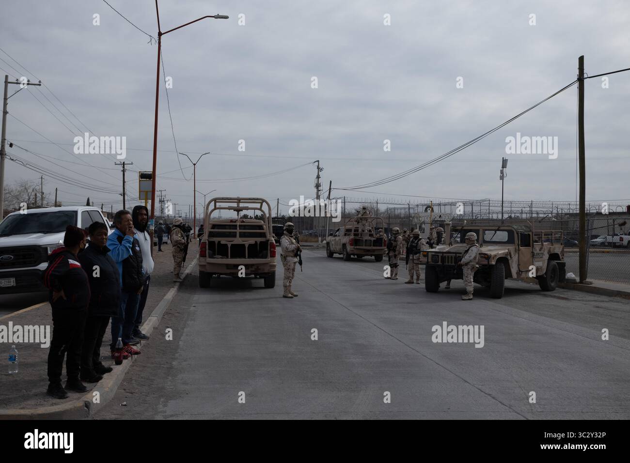 Des civils regardent les troupes patrouiller une zone sécurisée à Ciudad Juarez au milieu de la montée de la violence urbaine. Banque D'Images
