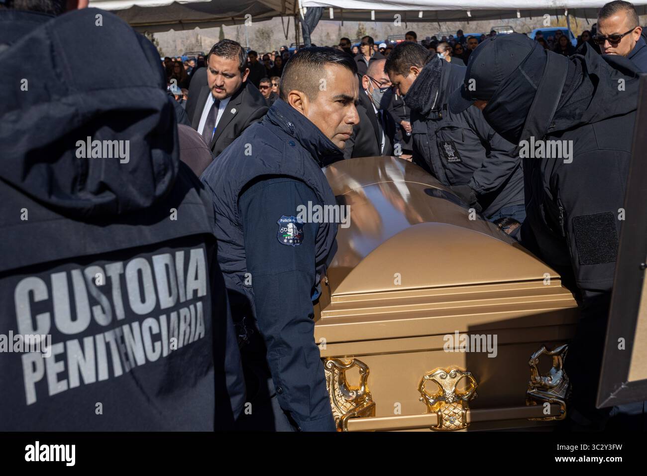 Les gardiens de prison de Ciudad Juarez portent un cercueil d'or lors d'un cortège funèbre, mettant en évidence les problèmes de violence et de respect pour les défunts. Banque D'Images