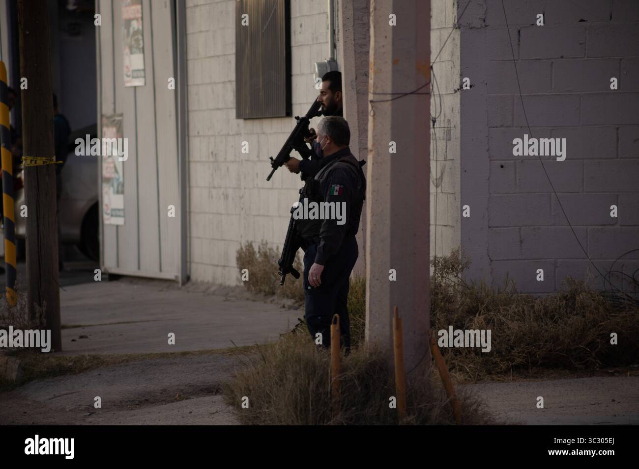 Des officiers armés dans des engins tactiques ciblent la violence urbaine près d'un bâtiment déserté à Ciudad Juarez. Banque D'Images