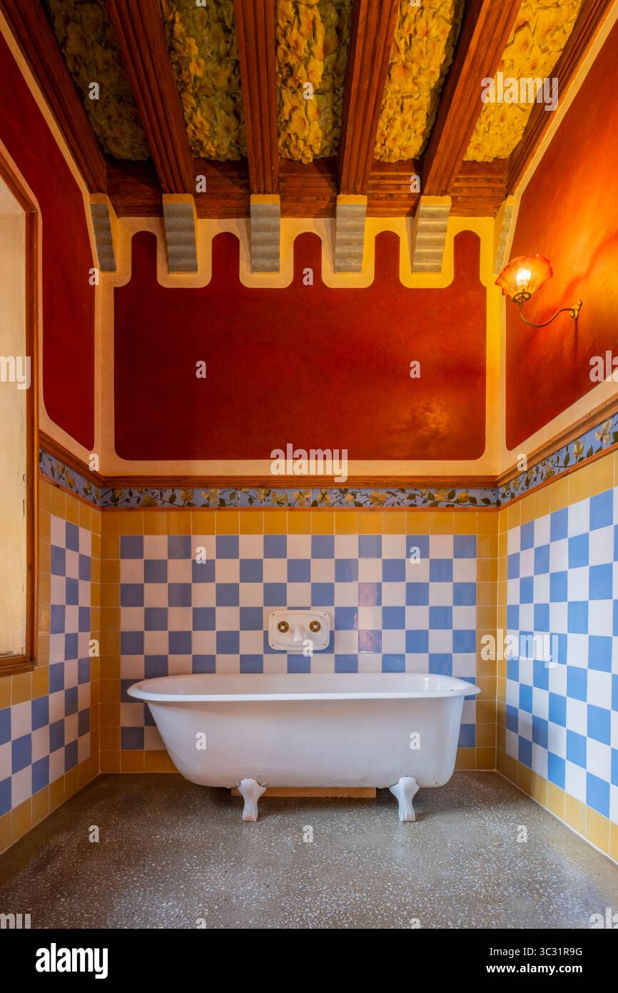 Salle de bain historique vibrante de Casa Vicens avec emblématique design moderniste Antoni Gaudi. Baignoire sur pieds, tuiles bleues et blanches frappantes, rouge chaud Banque D'Images