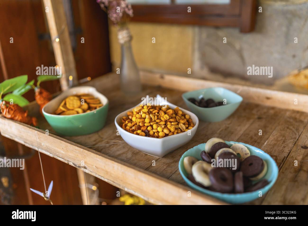 Bonbons et collations colorés servis sur un plateau en bois lors d'une célébration de mariage, ajoutant une touche de douceur et de plaisir à l'atmosphère festive Banque D'Images