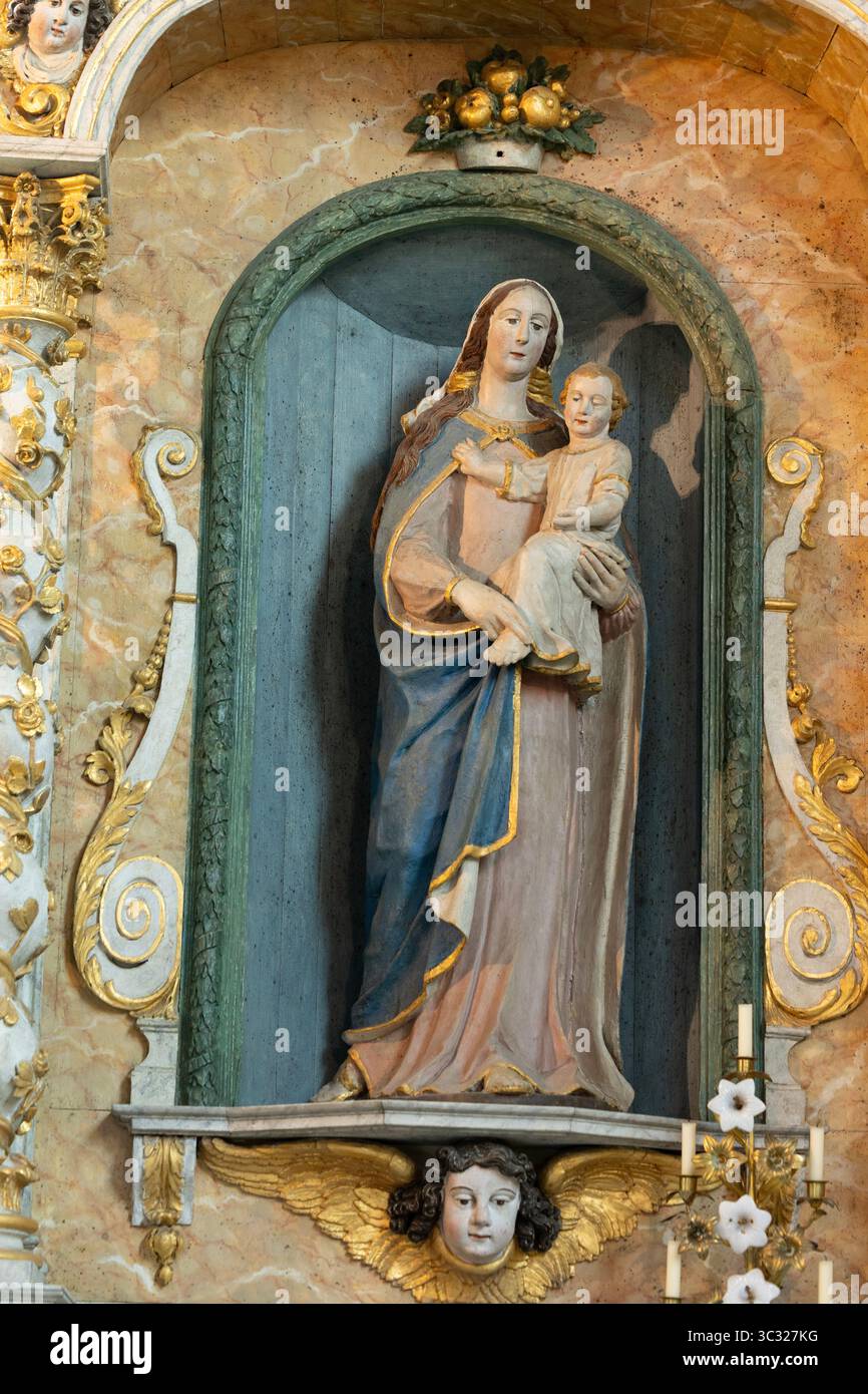 Statue en bois polychrome du XVIIe siècle de la Vierge à l'enfant à gauche du retable dans la chapelle Saint-Michel, Douarnenez, Bretagne, France. Banque D'Images