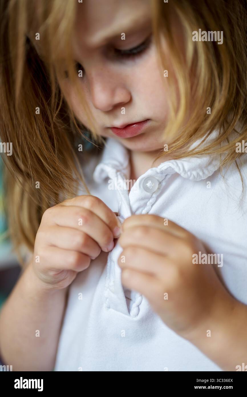 Enfant apprenant à s'habiller de manière indépendante, développement précoce Banque D'Images