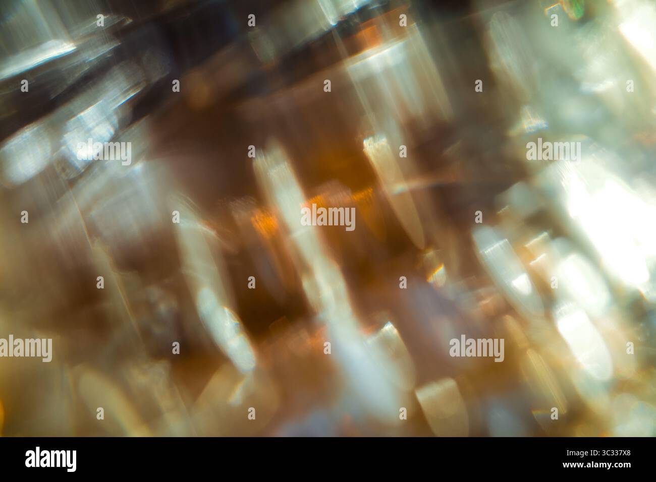 Des traînées lumineuses douces dans les tons ambre, or et blanc, capturées avec un flou de mouvement. Banque D'Images
