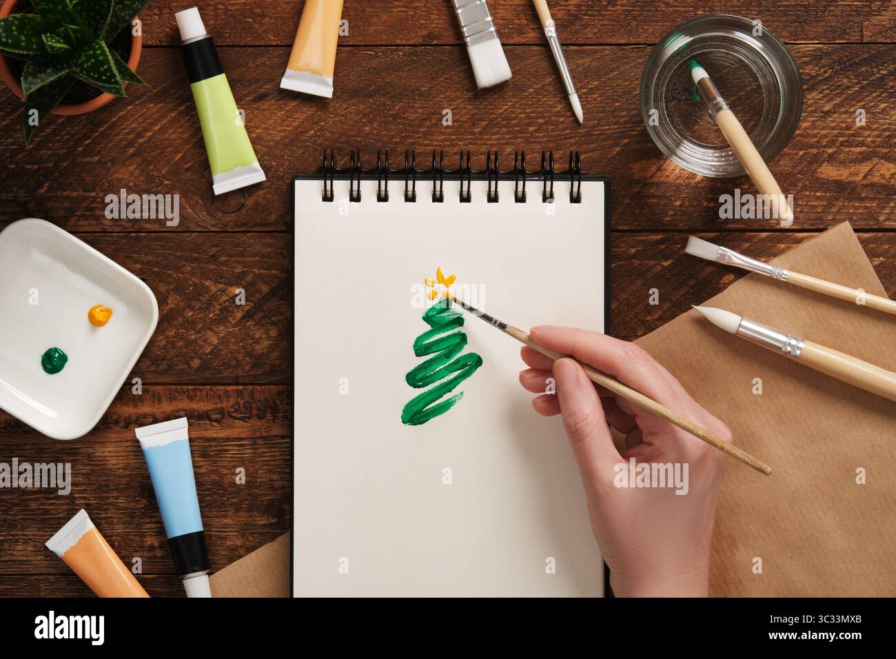 Peinture à la main d'un arbre de Noël vert simple sur un carnet de croquis. Concept artistique de vacances Banque D'Images