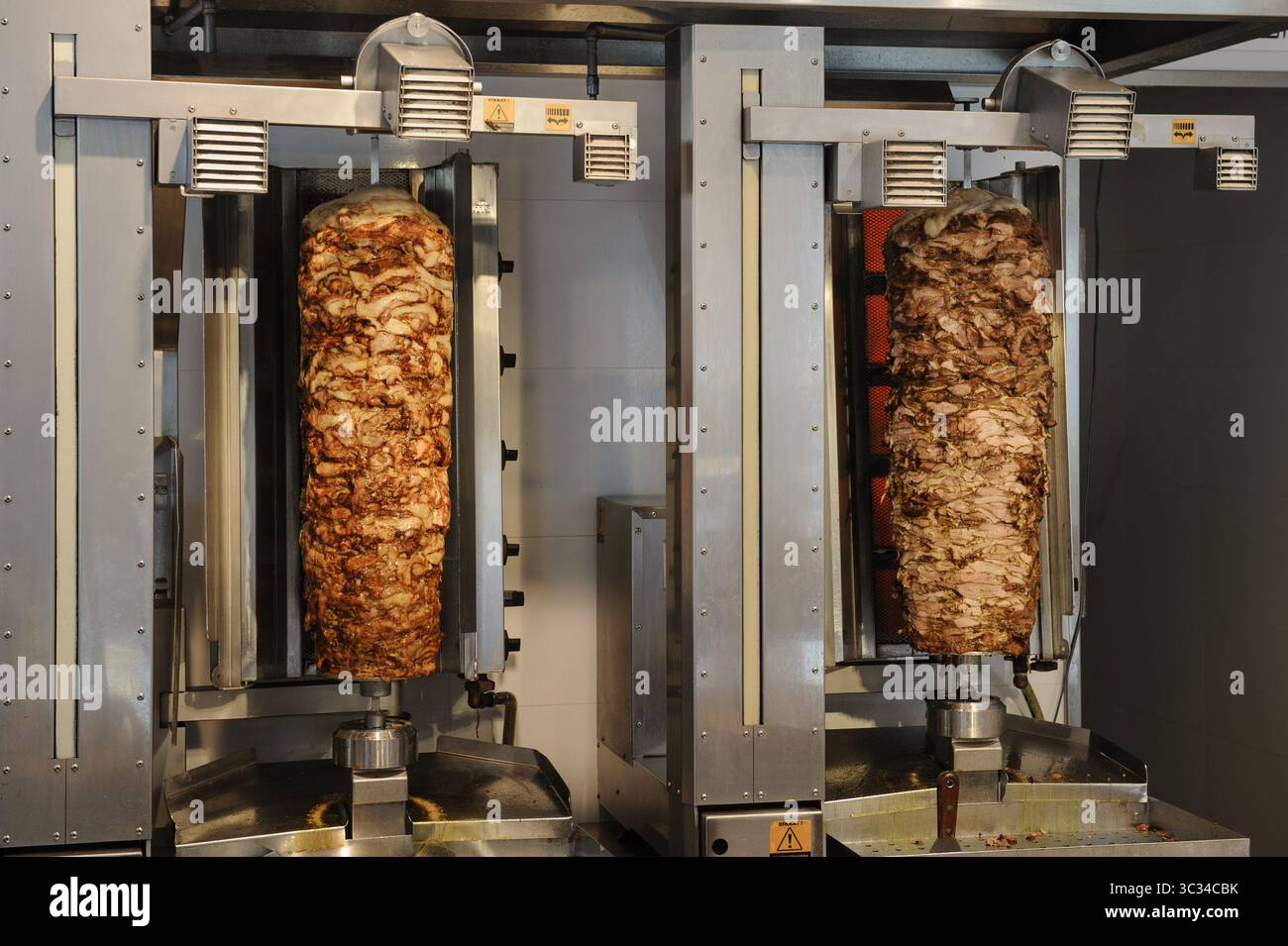 De grandes rôtisseries de viandes à rôtir dans un restaurant en Israël servant du shawarma, une cuisine de rue populaire du moyen-Orient. Banque D'Images