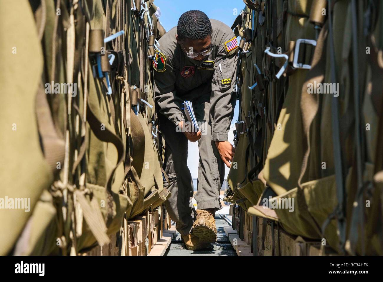 10 mars 2021 - Tokyo, Tokyo, Japon - L'aviateur Keion Buckley, maître de chargement du 36e escadron de transport aérien, vérifie les ensembles de systèmes de livraison de conteneurs de la Force d'autodéfense au sol japonaise avant leur téléchargement sur un C-130J Super Hercules pour un parachute dans le cadre de l'exercice Airborne 21 à la base aérienne de Yokota, Japon, le 10 mars 2021. La 374th Airlift Wing s'est associée à la JGSDF, 1st Airborne Brigade, pour le plus grand saut de ligne statique et le plus grand débarquement de fret entre les États-Unis et le Japon. La formation a permis aux unités américaines et japonaises de travailler côte à côte tout en améliorant l'état de préparation des deux forces. Banque D'Images
