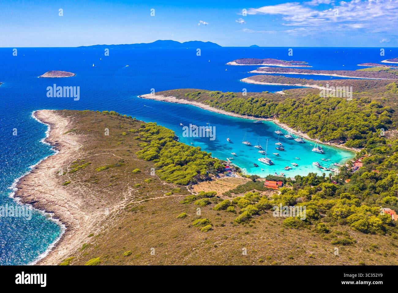Photo drone de la baie de Vinogradisce sur les îles Pakleni montrant l'eau turquoise, des yachts amarrés, une végétation luxuriante, une côte courbe et une scène sereine de l'Adriatique Banque D'Images Photo drone de la baie de Vinogradisce sur les îles Pakleni montrant l'eau turquoise, des yachts amarrés, une végétation luxuriante, une côte courbe et une scène sereine de l'Adriatique Banque D'Images