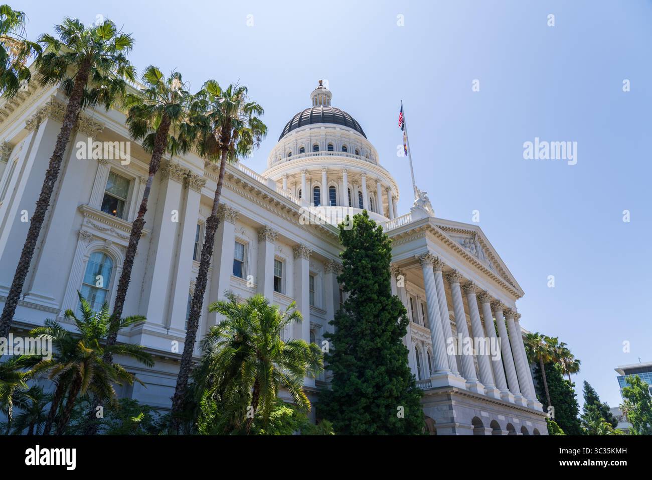 Sacramento, Californie, États-Unis - 21 juin 2025 : bâtiment historique du Capitole de Californie, vue latérale, avec drapeaux californien, américain et lgbtq Banque D'Images