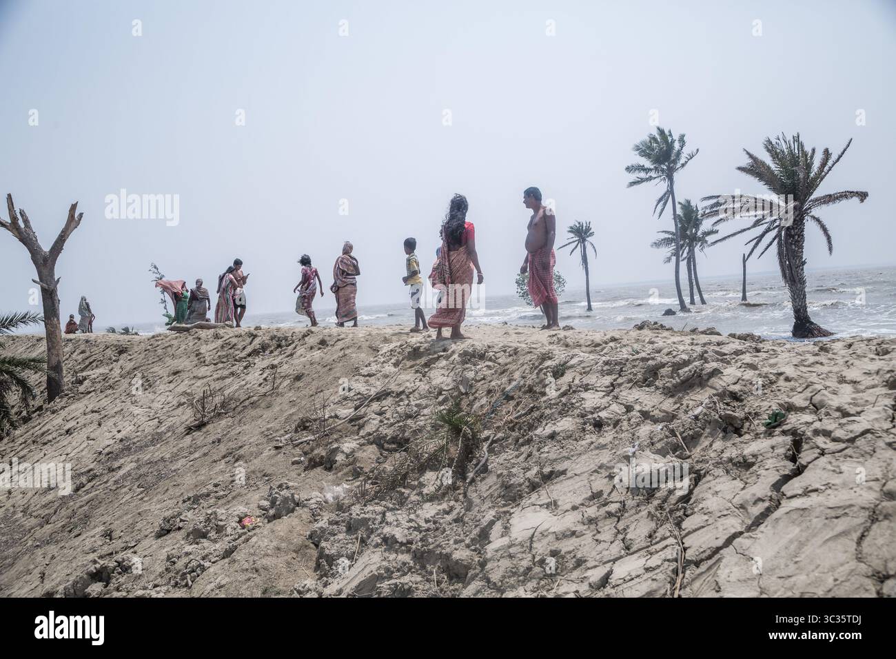 Le 30 mars 2021, Kolkata, Bengale occidental, Inde : les villageois de l'île de Ghoramara se tiennent devant leur village naufragé le jour précédent de la date des élections. Sundarbans, l'un des sites populaires du patrimoine mondial de l'UNESCO, est une préoccupation climatique croissante en raison de l'élévation du niveau de la mer. Sur les 52 îles habitées (sur 102), plusieurs îles sont maintenant au bord de la disparition. Au milieu de l'agitation des élections au Bengale occidental, aucun des partis politiques ne semble parler de l'incertitude climatique. Cependant, les habitants sont d'avis que la mer peut venir à tout moment aujourd'hui ou t Banque D'Images