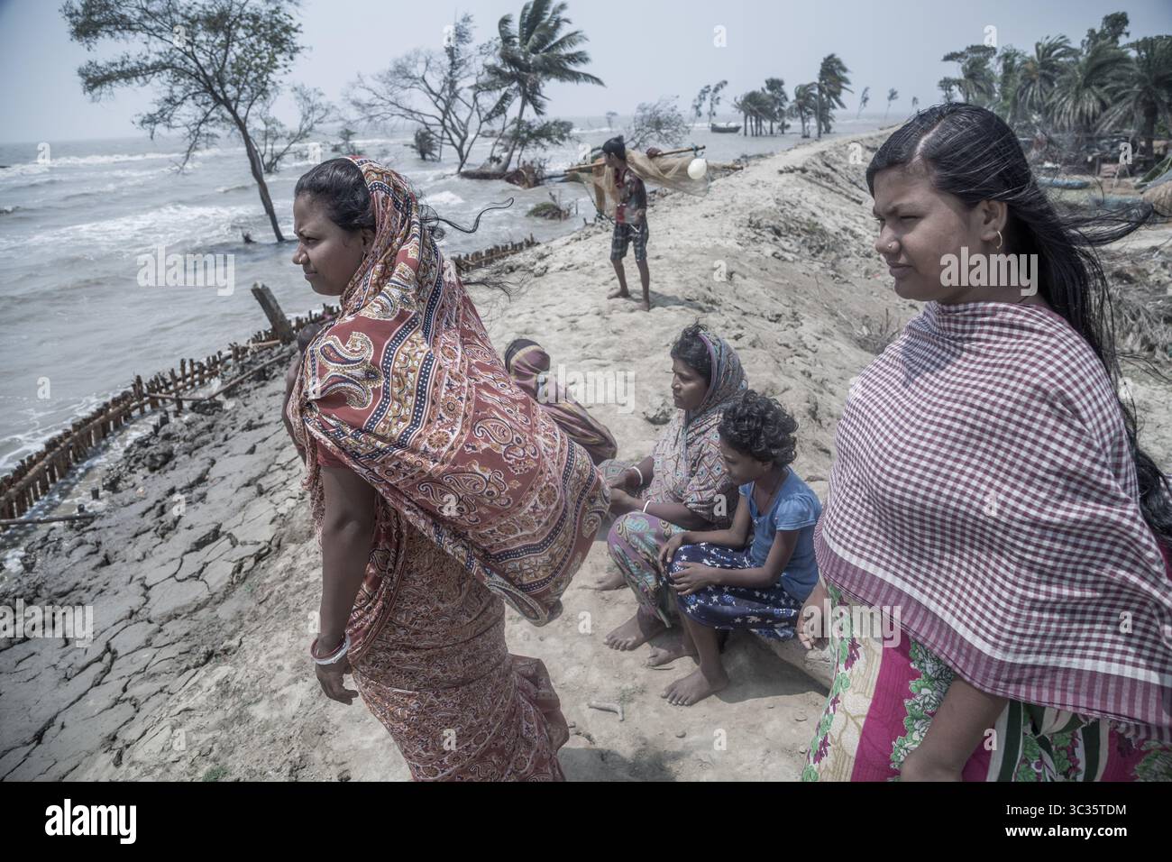 Le 30 mars 2021, Kolkata, Bengale occidental, Inde : les villageois de l'île de Ghoramara se tiennent devant leur village naufragé le jour précédent de la date des élections. Sundarbans, l'un des sites populaires du patrimoine mondial de l'UNESCO, est une préoccupation climatique croissante en raison de l'élévation du niveau de la mer. Sur les 52 îles habitées (sur 102), plusieurs îles sont maintenant au bord de la disparition. Au milieu de l'agitation des élections au Bengale occidental, aucun des partis politiques ne semble parler de l'incertitude climatique. Cependant, les habitants sont d'avis que la mer peut venir à tout moment aujourd'hui ou t Banque D'Images