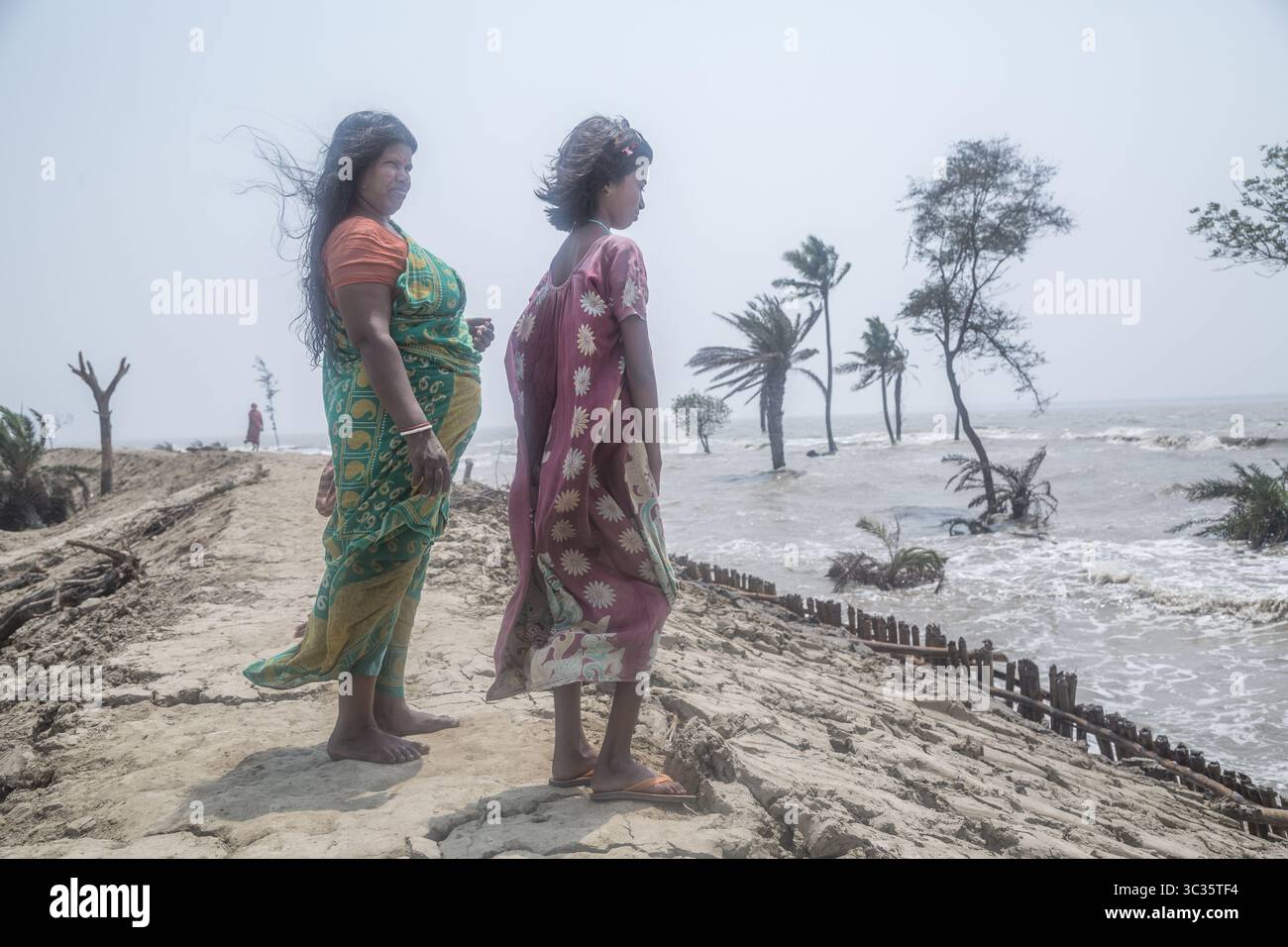 Le 30 mars 2021, Kolkata, Bengale occidental, Inde : les villageois de l'île de Ghoramara se tiennent devant leur village naufragé le jour précédent de la date des élections. Sundarbans, l'un des sites populaires du patrimoine mondial de l'UNESCO, est une préoccupation climatique croissante en raison de l'élévation du niveau de la mer. Sur les 52 îles habitées (sur 102), plusieurs îles sont maintenant au bord de la disparition. Au milieu de l'agitation des élections au Bengale occidental, aucun des partis politiques ne semble parler de l'incertitude climatique. Cependant, les habitants sont d'avis que la mer peut venir à tout moment aujourd'hui ou t Banque D'Images