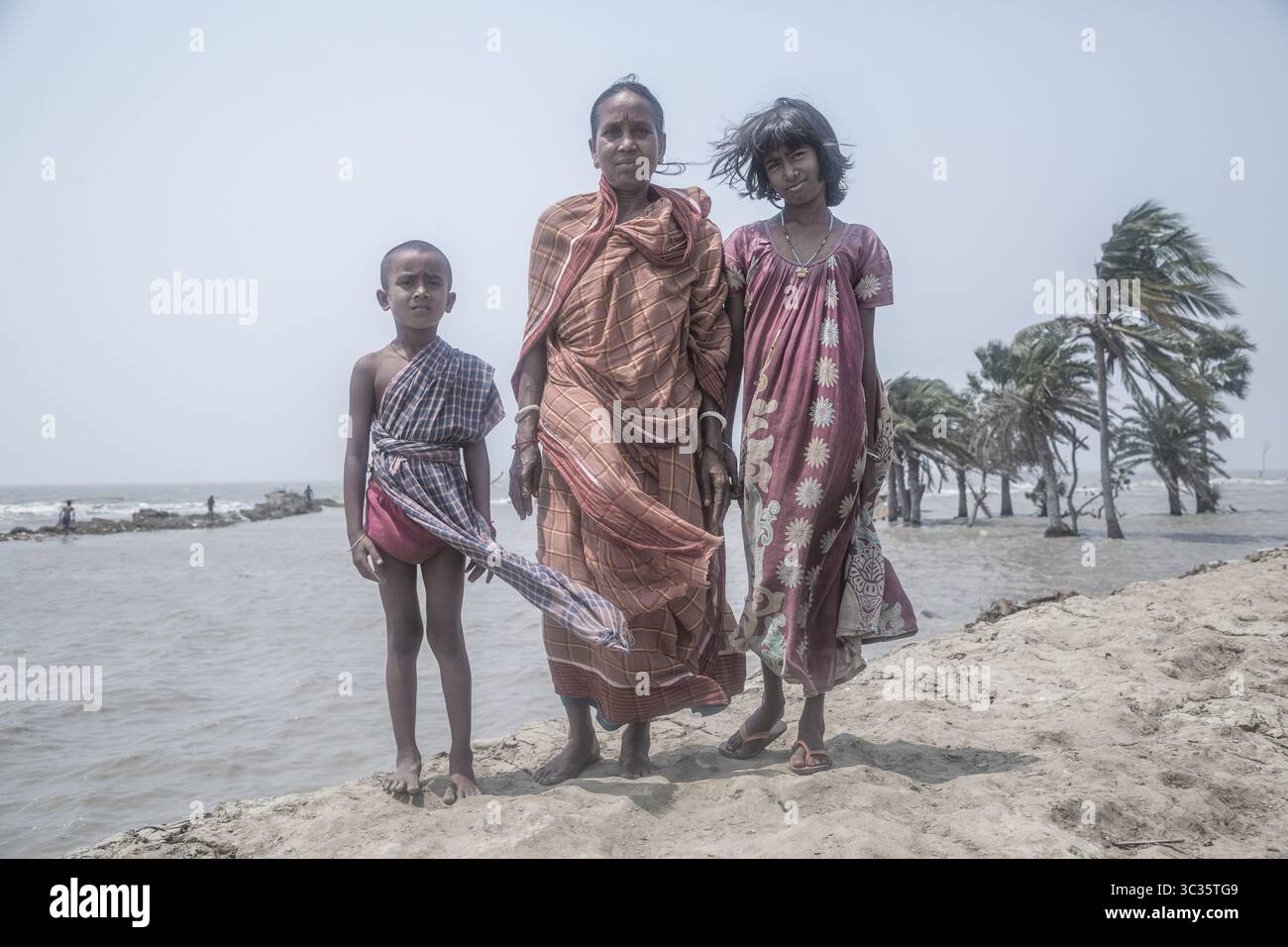 Le 30 mars 2021, Kolkata, Bengale occidental, Inde : les villageois de l'île de Ghoramara se tiennent devant leur village naufragé le jour précédent de la date des élections. Sundarbans, l'un des sites populaires du patrimoine mondial de l'UNESCO, est une préoccupation climatique croissante en raison de l'élévation du niveau de la mer. Sur les 52 îles habitées (sur 102), plusieurs îles sont maintenant au bord de la disparition. Au milieu de l'agitation des élections au Bengale occidental, aucun des partis politiques ne semble parler de l'incertitude climatique. Cependant, les habitants sont d'avis que la mer peut venir à tout moment aujourd'hui ou t Banque D'Images