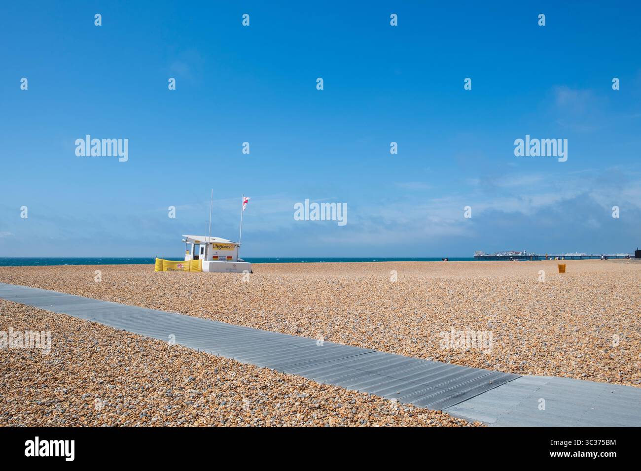 Plage de galets et ciel bleu profond à Blackrock, Brighton, Royaume-Uni avec sauveteur et station de sauvetage Banque D'Images