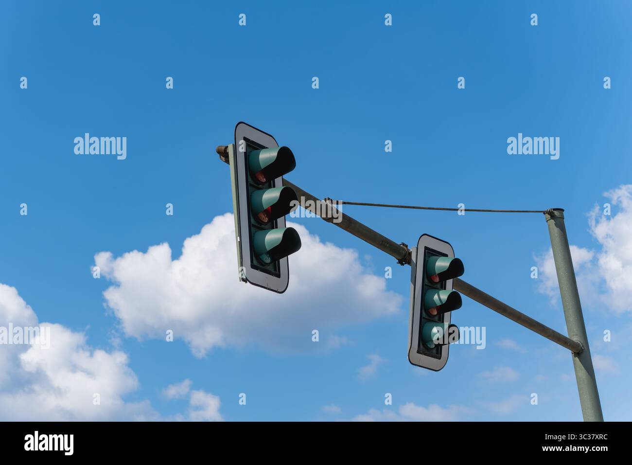 Feux de circulation contre un ciel bleu. Deux feux de circulation contre un ciel nuageux, photographiés légèrement d'en bas. Photo symbolique pour la circulation et la LIF urbaine Banque D'Images