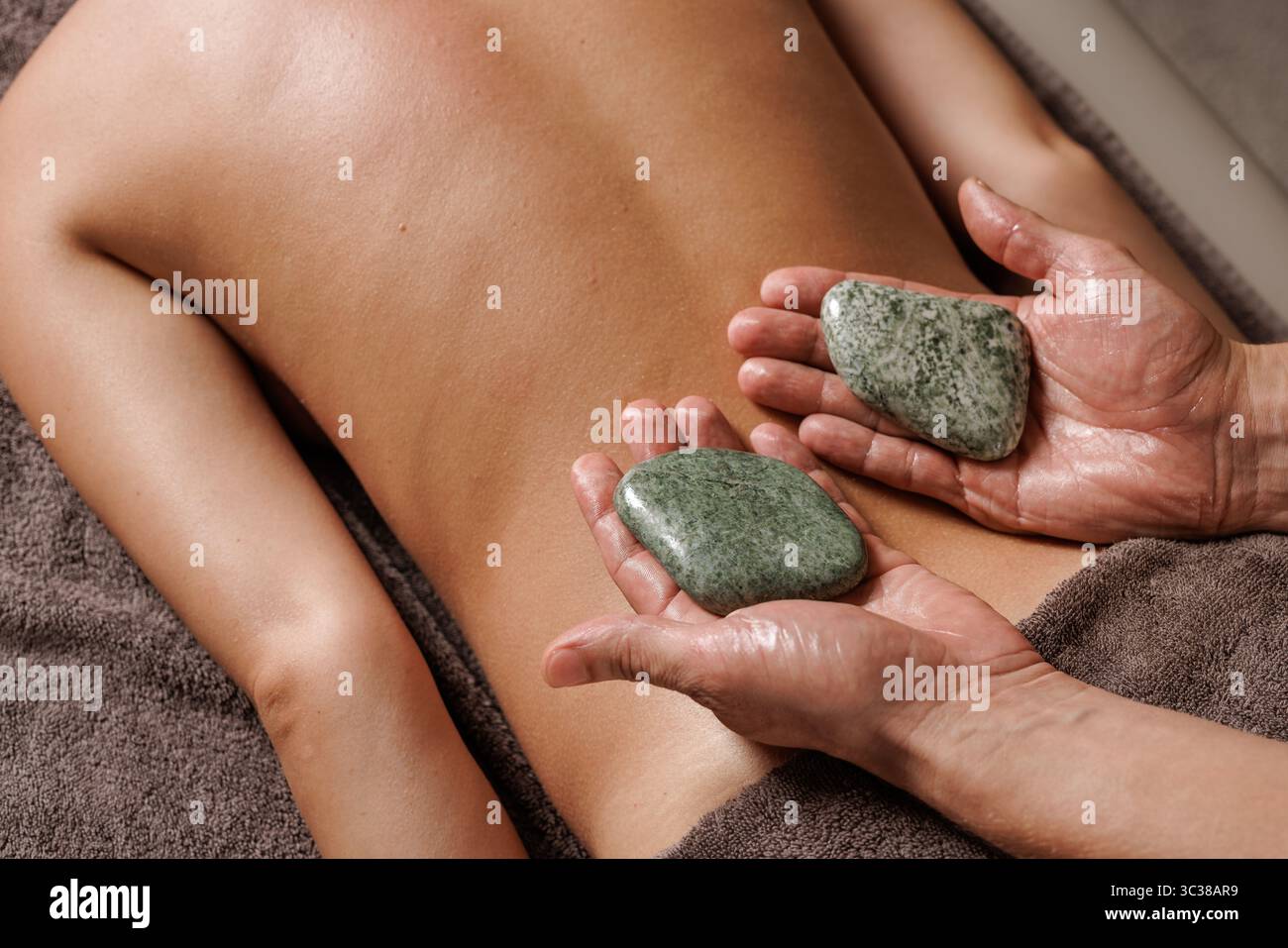 Massage aux pierres de bien-être pour la relaxation profonde, le soulagement des douleurs musculaires, la récupération du stress, de la fatigue et de l'insomnie. Banque D'Images