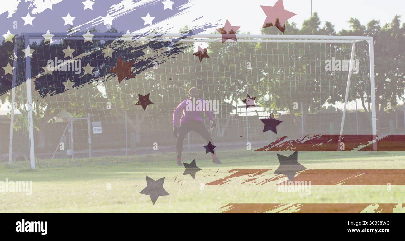 Gardien de but adolescent debout gardant le but sur le terrain, avec maillot violet, gants et recouvrement de drapeau Banque D'Images Gardien de but adolescent debout gardant le but sur le terrain, avec maillot violet, gants et recouvrement de drapeau Banque D'Images
