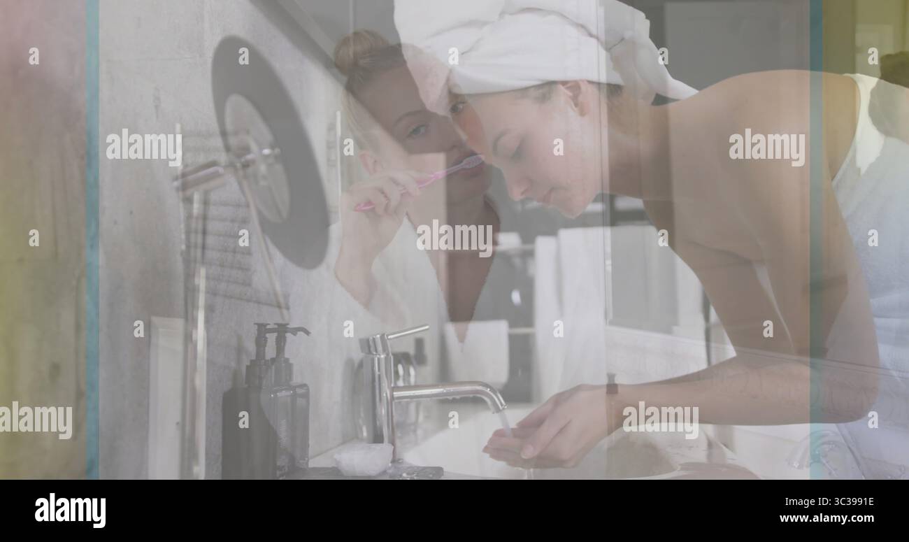 Femme de lavage se penchant sur le robinet de l'évier tandis que l'ami se brossant les dents avec une brosse à dents dans la salle de bains à la maison Banque D'Images Femme de lavage se penchant sur le robinet de l'évier tandis que l'ami se brossant les dents avec une brosse à dents dans la salle de bains à la maison Banque D'Images