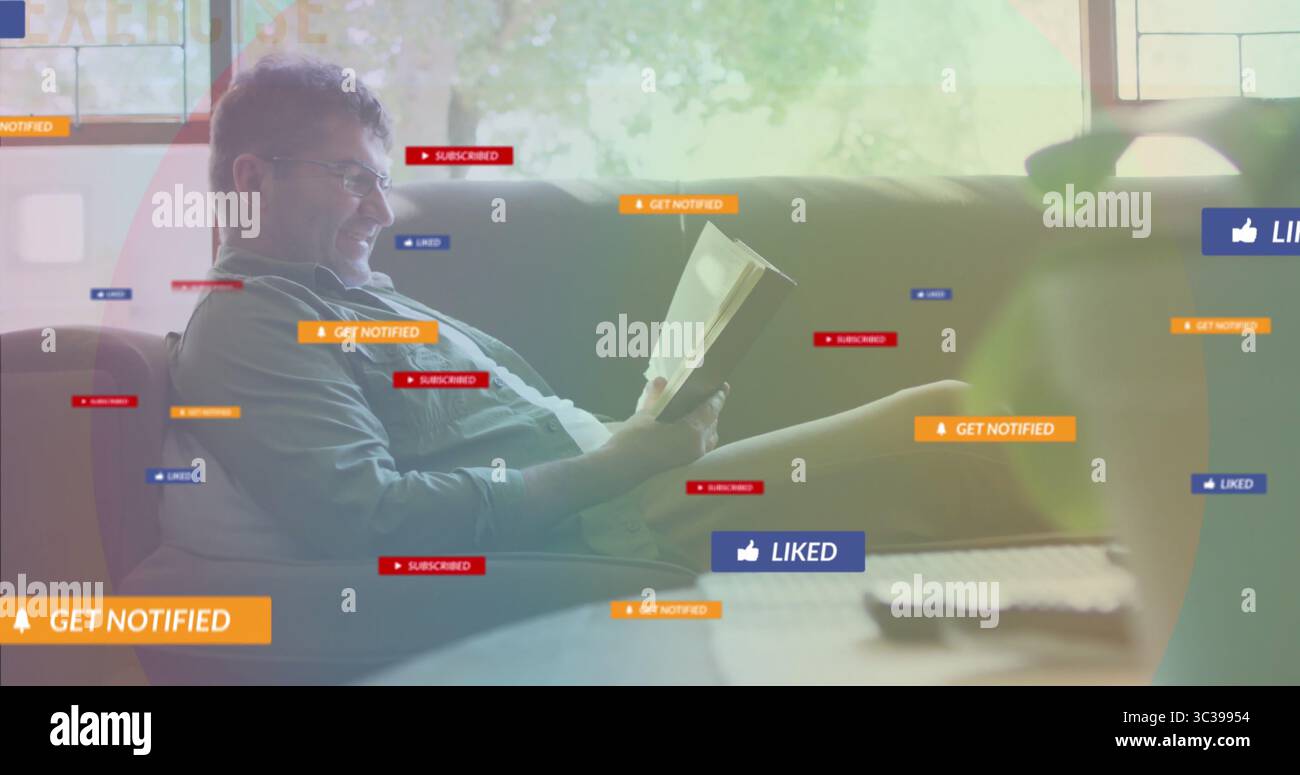 Homme lisant livre de poche sur canapé dans le salon, avec télécommande TV et graphiques de notification Banque D'Images Homme lisant livre de poche sur canapé dans le salon, avec télécommande TV et graphiques de notification Banque D'Images