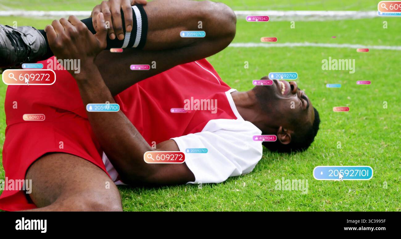 S'agrippant le genou droit tout en étant allongé sur un terrain en herbe portant un maillot rouge, des chaussettes rayées et des étiquettes numériques Banque D'Images S'agrippant le genou droit tout en étant allongé sur un terrain en herbe portant un maillot rouge, des chaussettes rayées et des étiquettes numériques Banque D'Images
