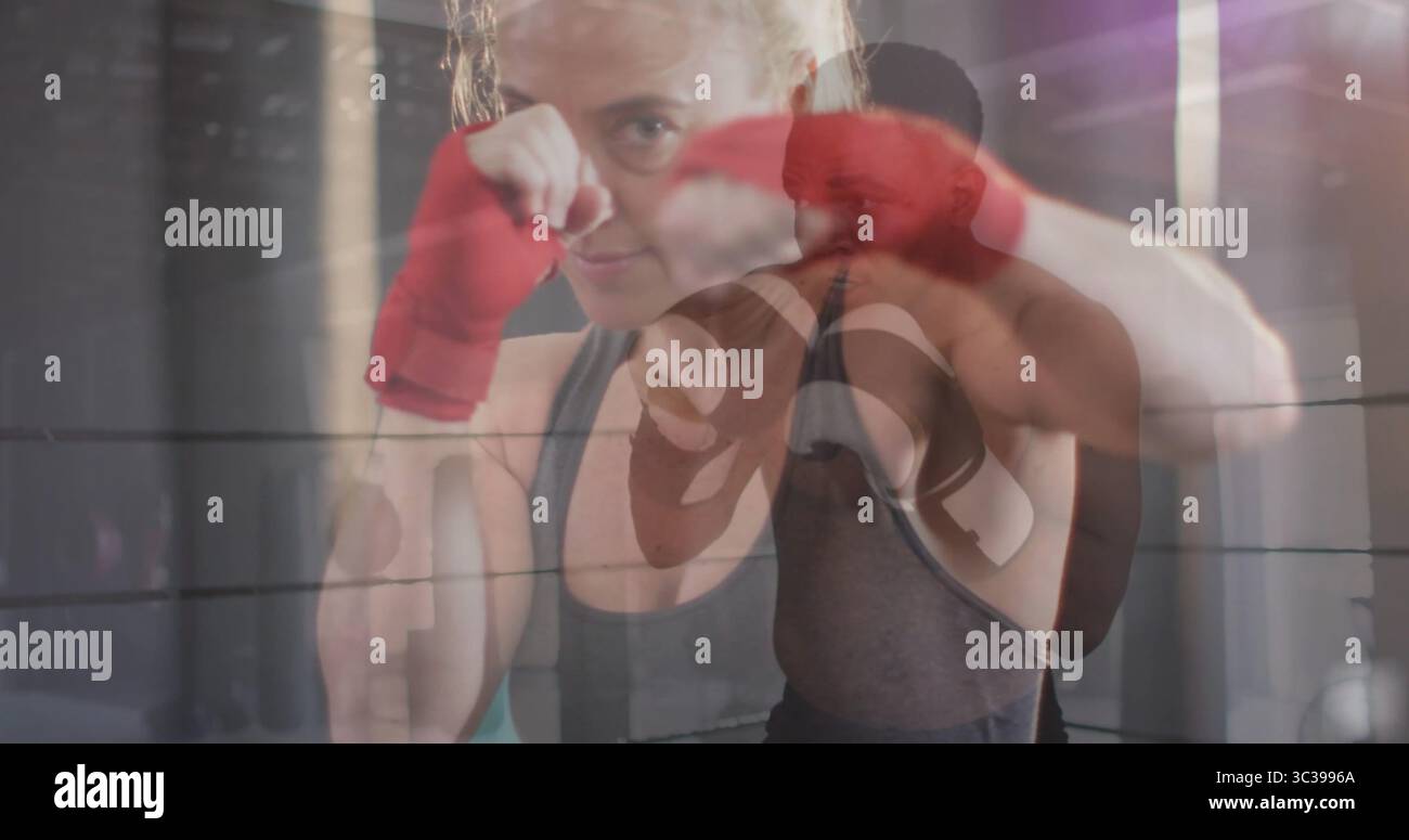 Boxer de protection dans le débardeur levant les poings dans l'anneau de boxe, avec des enveloppes rouges et des gants noirs Banque D'Images Boxer de protection dans le débardeur levant les poings dans l'anneau de boxe, avec des enveloppes rouges et des gants noirs Banque D'Images
