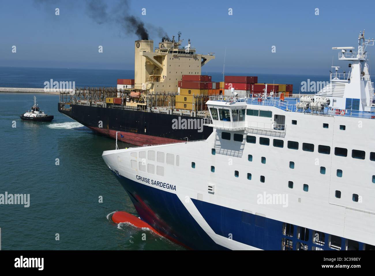 Les navires de passage à Livourne Italie alors que le MSC Agadir entre dans le port à l'aide de remorqueurs tandis que le ferry de Grimaldi Lines Cruise Sardegna part Banque D'Images