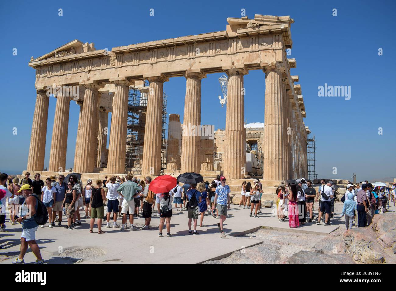 Athènes, Grèce, 24 juillet 2025. Les gens visitent l'Acropole, certains d'entre eux ombragés sous des parapluies. Une vague de chaleur sévère frappe la Grèce, poussant les températures à des sommets de plus de 42 degrés Celsius à Athènes et dans d'autres villes. Crédit : Dimitris Aspiotis/Alamy Banque D'Images