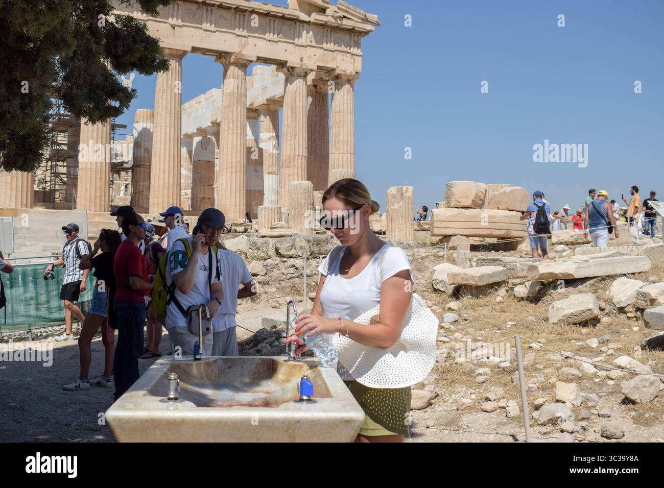 Athènes, Grèce, 24 juillet 2025. Les gens se rafraîchissent avec l'eau du robinet lors de la visite de l'Acropole. Une vague de chaleur sévère frappe la Grèce, poussant les températures à des sommets de plus de 42 degrés Celsius à Athènes et dans d'autres villes. Crédit : Dimitris Aspiotis/Alamy Banque D'Images