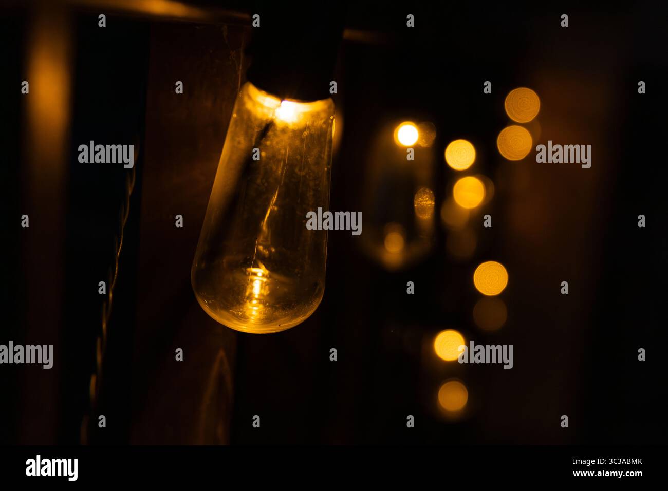 Ampoules émettant une lueur chaleureuse et accueillante, créant une ambiance chaleureuse et intime dans un cadre sombre Banque D'Images