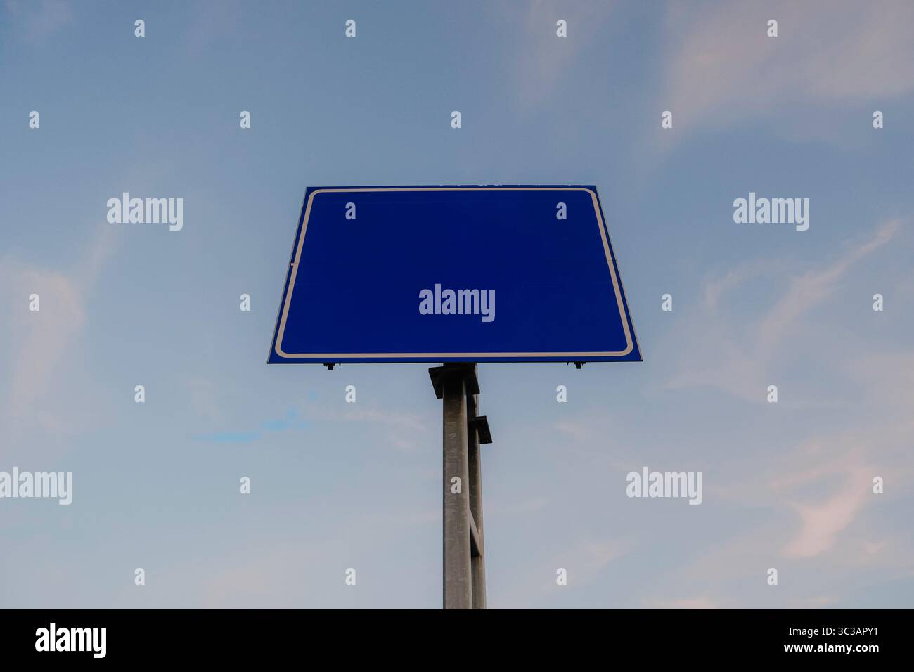 Panneau de route bleu vierge contre le ciel clair, parfait pour l'espace de copie ou la maquette de conception Banque D'Images