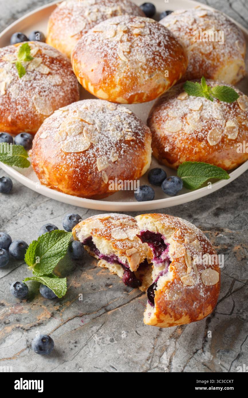 Brioches traditionnelles avec remplissage de myrtille en gros plan sur l'assiette sur la table. Vertical Banque D'Images