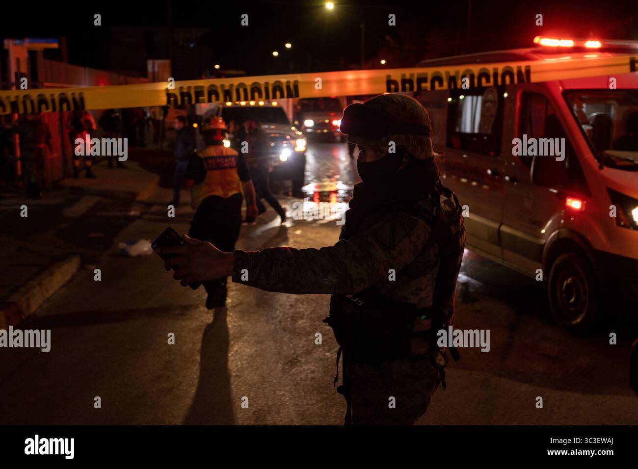 Les forces de sécurité gèrent la circulation lors d'une nuit violente à Ciudad Juarez, baignée par la lumière des ambulances. Banque D'Images