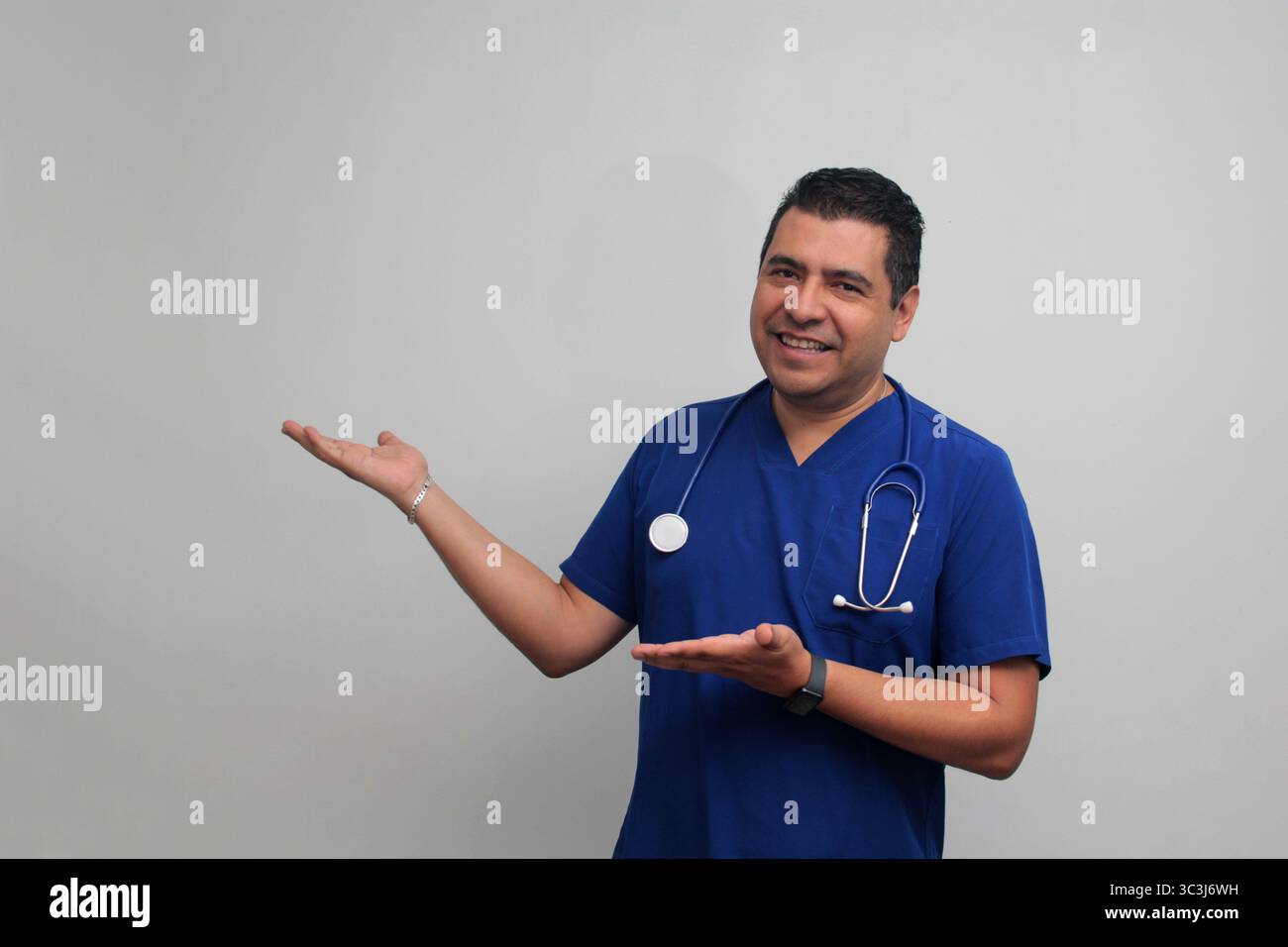Médecin spécialiste latino-américain à la peau foncée avec un stéthoscope pointe avec son doigt avec une expression de joie et de surprise Banque D'Images Médecin spécialiste latino-américain à la peau foncée avec un stéthoscope pointe avec son doigt avec une expression de joie et de surprise Banque D'Images