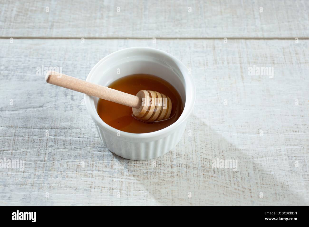 Une vue d'une trempette de miel dans un bol de miel. Banque D'Images