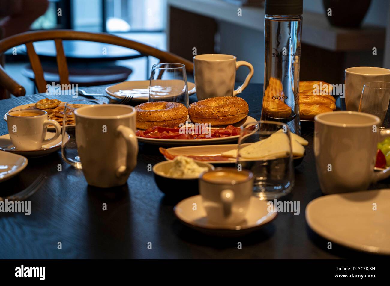 Petit déjeuner préparé à table avec bagels au fromage et café prêt à déguster en famille. Banque D'Images