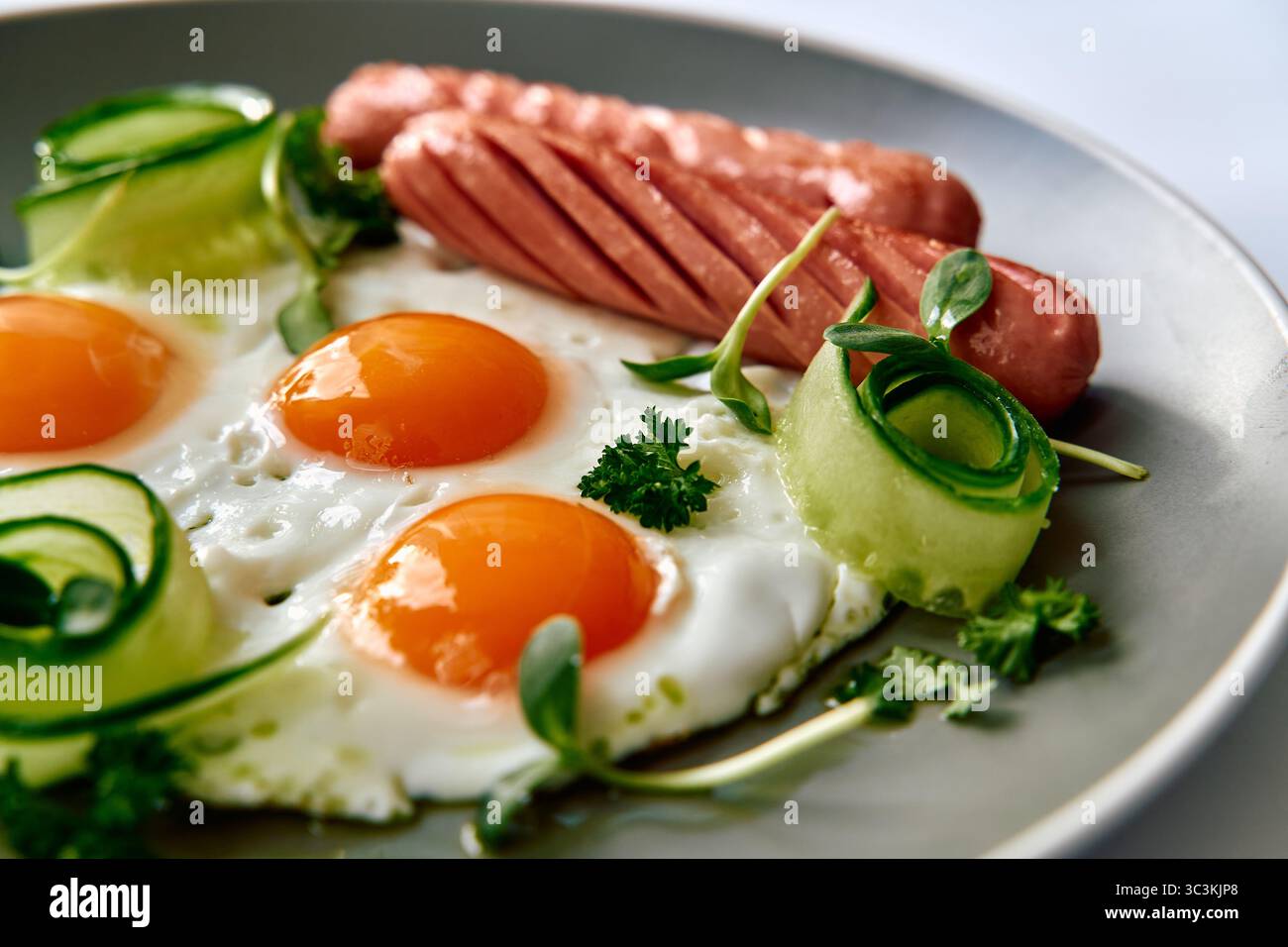 Délicieux plateau de petit déjeuner avec œufs et saucisses Sunny-Side-Up accompagnés de légumes frais pour un début de journée nutritif Banque D'Images
