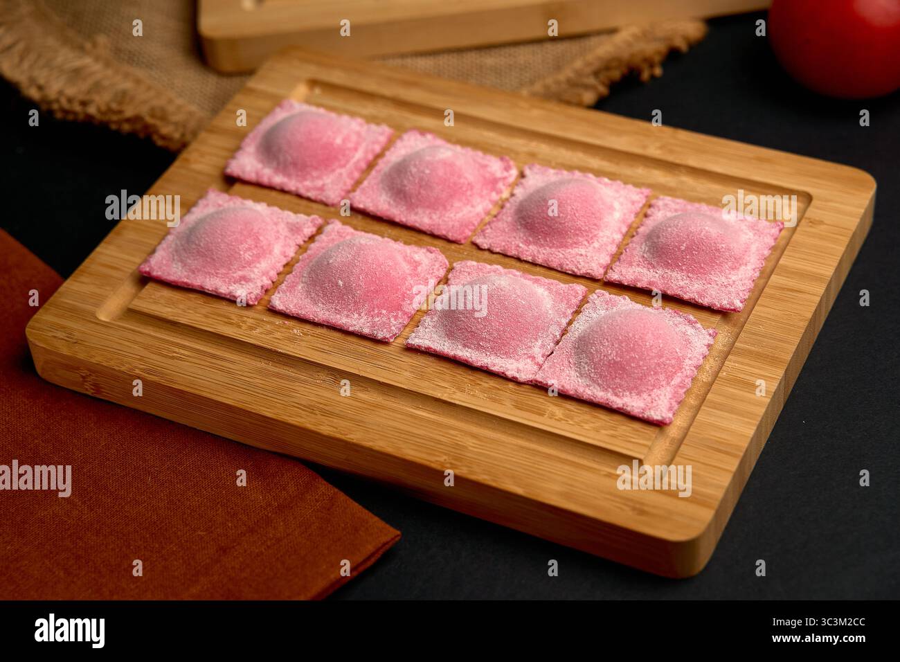 Boulettes roses délicates disposées sur une planche en bois avec un fond rustique, mettant en valeur leur couleur unique et leur attrait textural pour les passionnés culinaires Banque D'Images