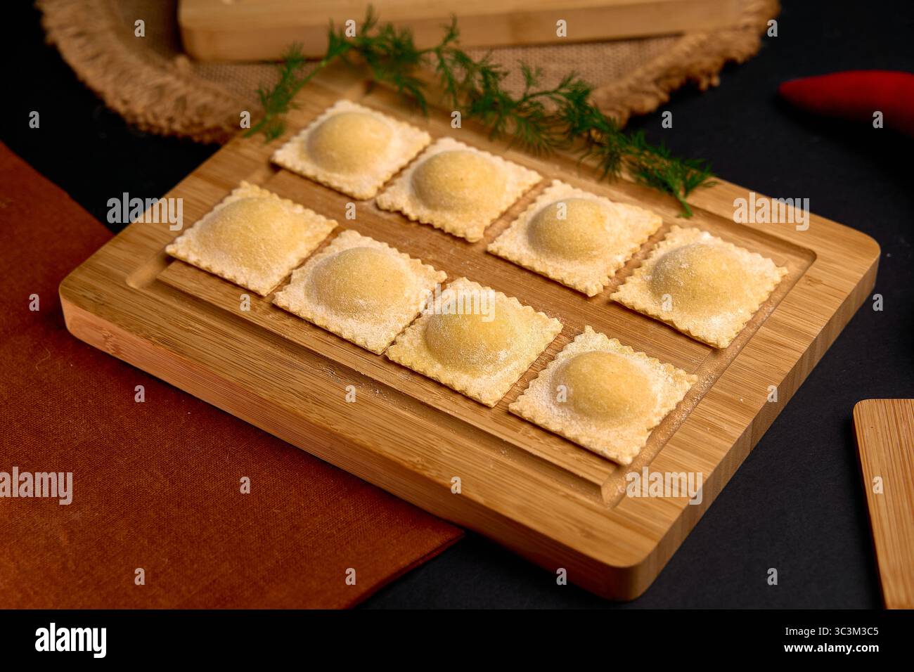 Raviolis délicieusement fabriqués sur une planche de bois avec des ingrédients frais et une touche de glamour capturant l'essence de l'art culinaire Banque D'Images