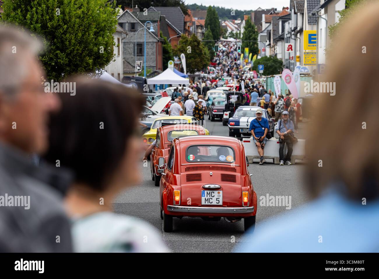Wettenberg, Allemagne. 26 juillet 2025. Les voitures anciennes circulent le long de la rue principale. Pour la 34e fois, le Golden Oldies Festival fait revivre la période des années 1950 aux années 1980 avec musique, mode et voitures anciennes. Crédit : Christian Lademann/dpa/Alamy Live News Banque D'Images