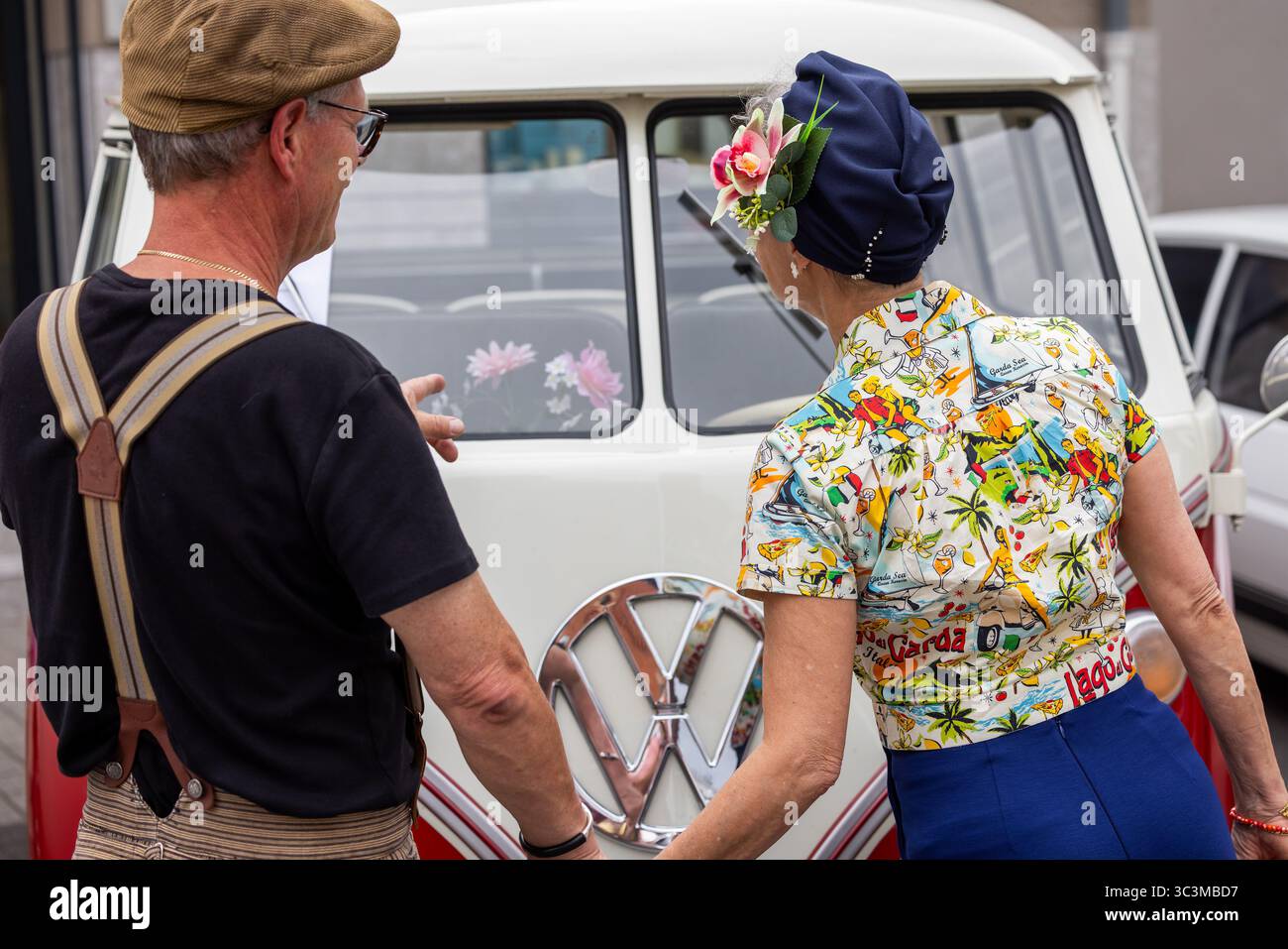 Wettenberg, Allemagne. 26 juillet 2025. Une paire de visiteurs s'émerveille devant un vieux bus VW. Pour la 34e fois, le Golden Oldies Festival fait revivre la période des années 1950 aux années 1980 avec musique, mode et voitures anciennes. Crédit : Christian Lademann/dpa/Alamy Live News Banque D'Images