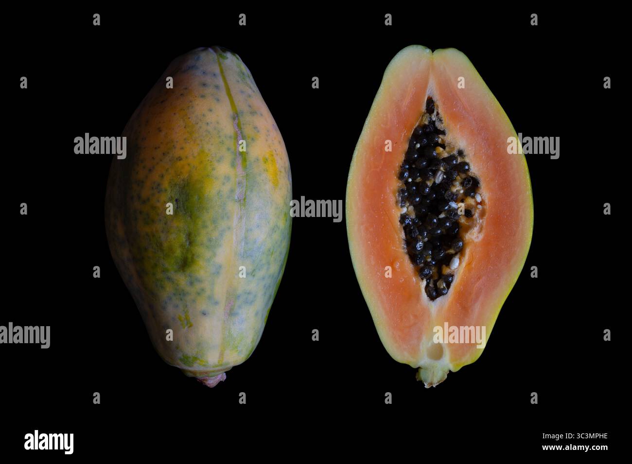 Fruit de papaye. A l'extérieur et à l'intérieur d'un fruit mûr de papaye (Carica papaya), l'un des fruits tropicaux les plus populaires au monde. Fond noir Banque D'Images