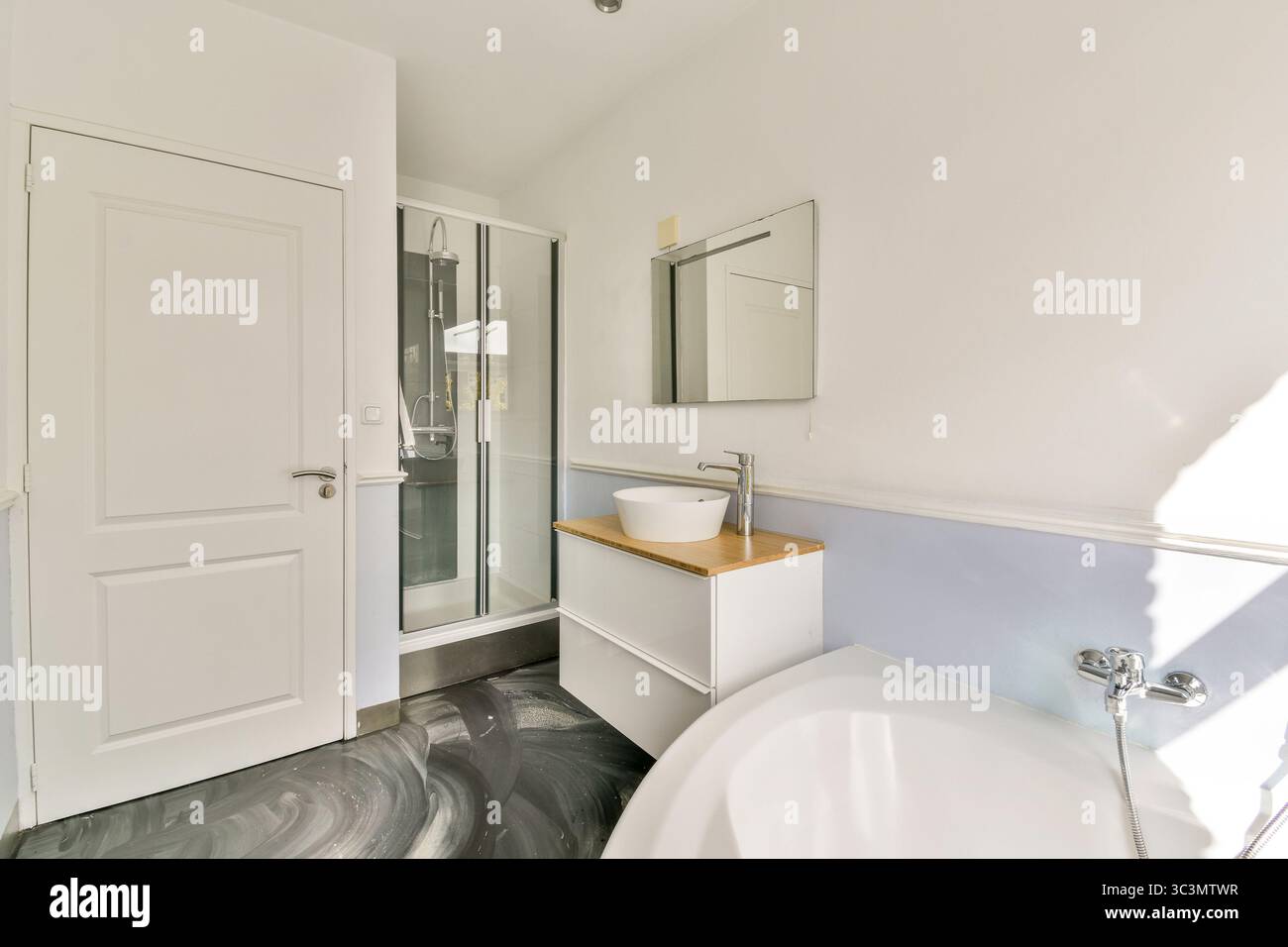 Cette image met en valeur une salle de bains contemporaine avec une douche élégante, des luminaires modernes et des solutions de rangement élégantes, mettant l'accent sur un design minimaliste Banque D'Images