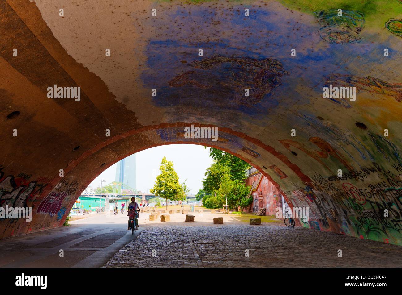 Francfort, Allemagne - 10 juin 2025 : arche murale vibrante avec passage d'un cycliste dans un paysage urbain. Banque D'Images