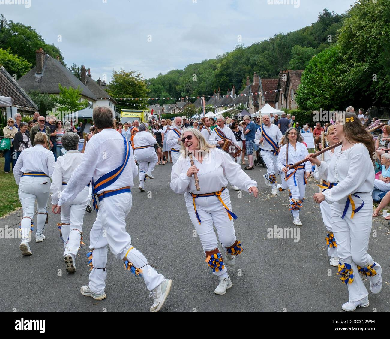 Milton Abbas, Dorset, Royaume-Uni. 26 juillet 2025. Milton Abbas a été fermé à la circulation alors que les villageois et les visiteurs remontaient dans le temps pour profiter de la Biennale Street Fair du XVIIIe siècle, où les villageois et les détenteurs de stands s'habillent de costumes traditionnels. La ville originale (appelée Middleton) a été démolie et déplacée dans la vallée suivante parce que Joseph Damer (plus tard Lord Milton 1er comte de Dorchester) n'aimait pas sa proximité avec sa grande maison. La foire, qui a lieu tous les deux ans, a été relancée lorsque les résidents actuels ont voulu célébrer la fondation du nouveau village de Milton Abbas. Crédit : Tom Corban/Al Banque D'Images