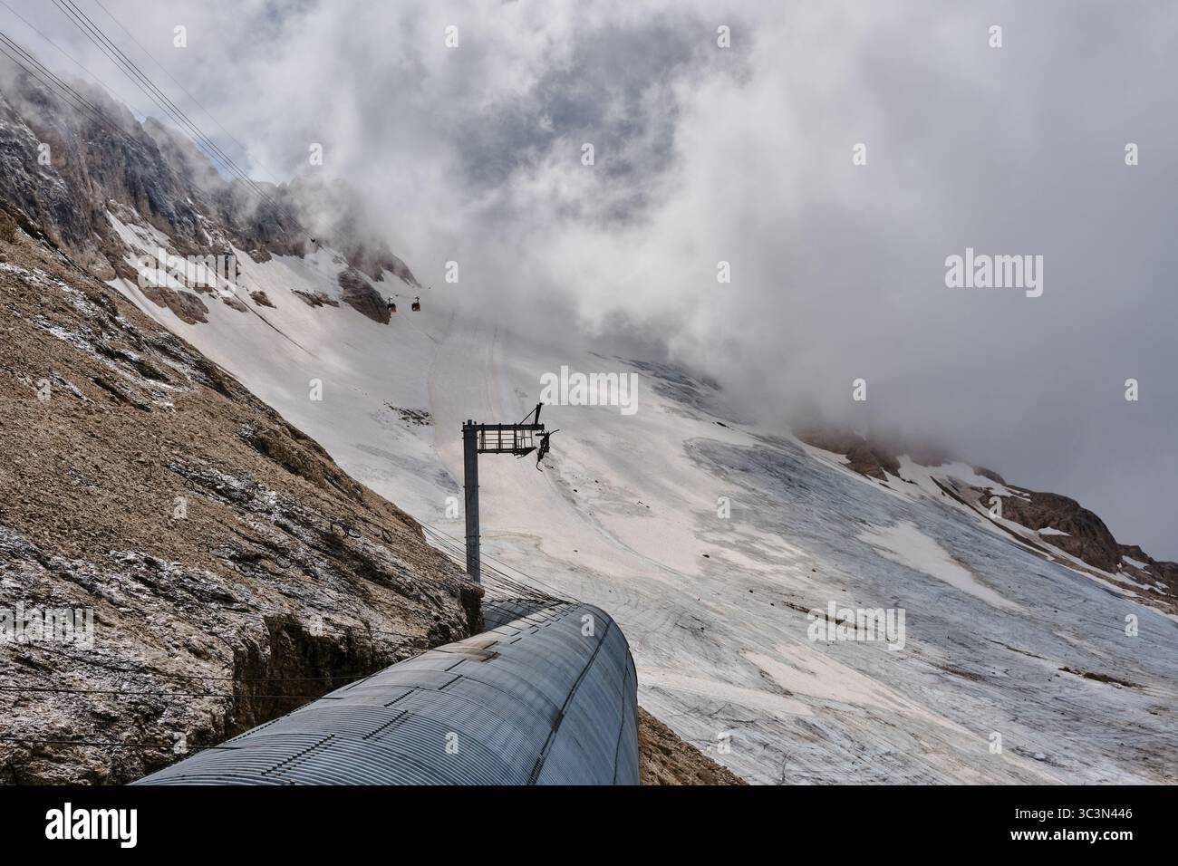Le glacier Marmolada en juillet 2025 depuis l'arrêt Serauta sur le téléphérique Malga Ciapela avec la sortie du tunnel des pistes de ski Banque D'Images