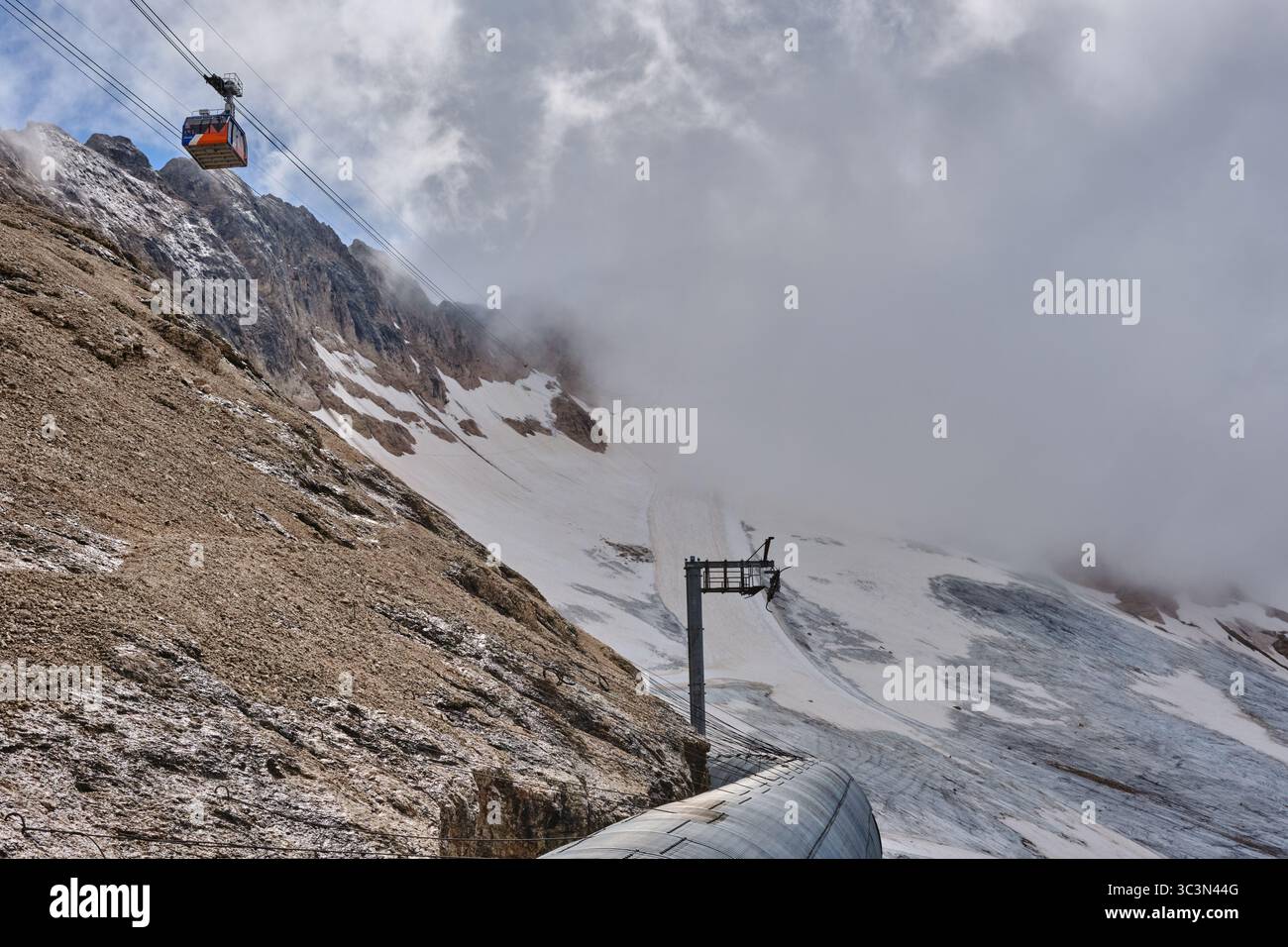 Le glacier Marmolada en juillet 2025 depuis l'arrêt Serauta sur le téléphérique Malga Ciapela avec la sortie du tunnel des pistes de ski Banque D'Images